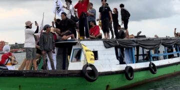 orasi aktivis di atas perahu yang melaju di Teluk Balikpapan (Dok: Sirana.id)