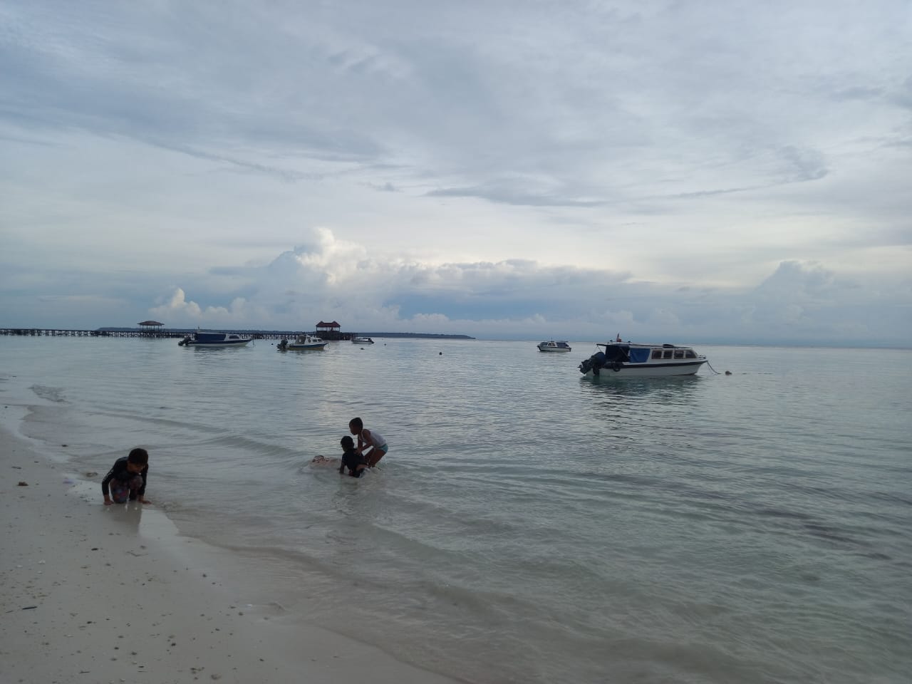 Anak-anak yang bermain di tepi pantai Maratua