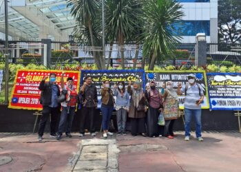 Protes para dosen dengan latar belakang karangan bunga yang berisi ujaran protes (foto: ADAKSI)