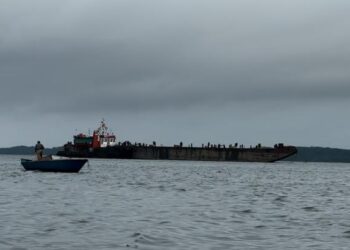 Nelayan dan kapal tongkang di Teluk Balikpapan (Foto: Nofiyatul Chalimah)