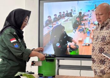 Yunita (kiri) saat menunjukkan cara kerja kompor biobriket hasil inovasi timnya, kepada para peserta diseminasi dan Ketua Dewan Pembina Yayasan Mitra Hijau Dicky Edwin