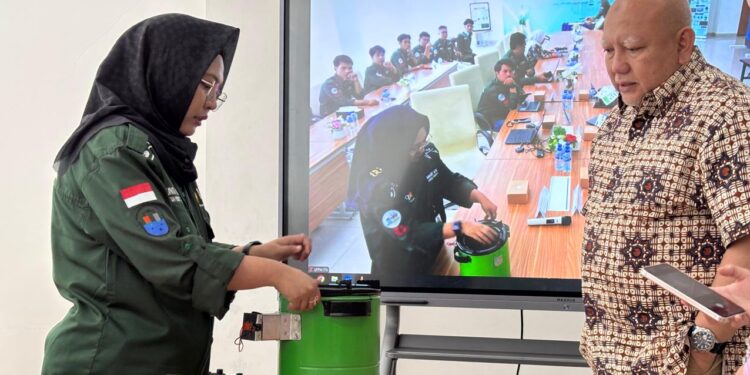 Yunita (kiri) saat menunjukkan cara kerja kompor biobriket hasil inovasi timnya, kepada para peserta diseminasi dan Ketua Dewan Pembina Yayasan Mitra Hijau Dicky Edwin