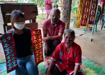 FE Lebiq, Sisilia Ramla, dan cucu mereka, memamerkan motif kriookng dalam pameran di Kampung Linggang Melapeh pada akhir 2021 (foto: Nofiyatul Chalimah)